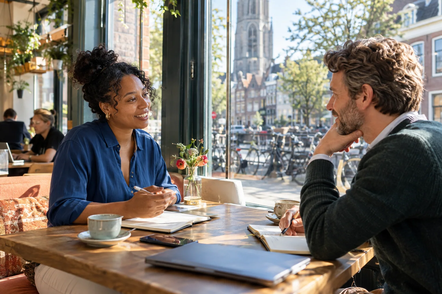Kandidaat en recruiter voeren een open gesprek in een zonnige Nederlandse omgeving